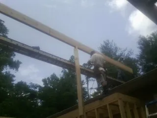 Carpenter setting a ridge beam over a new addition frame — Ice Dam Removal by Roofing Brothers in Northwood